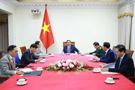 El primer ministro de Vietnam, Pham Minh Chinh, sostiene una conversación telefónica con su homólogo de Malasia, Anwar Ibrahim. (Fuente: VNA)