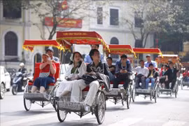 Turistas experimentan un recorrido en triciclo por el lago Hoan Kiem. (Foto: VNA)