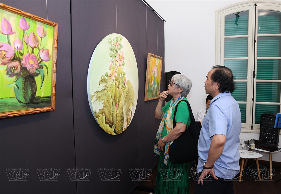 Invitados visitan y disfrutan de las pinturas de loto. (Fuente:VNA)