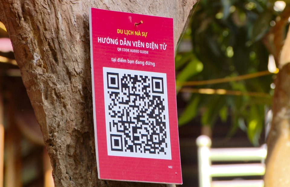 Visitantes escanean el código QR para obtener información sobre los servicios de la aldea turística comunitaria de Na Su. (Fuente:VNA)
