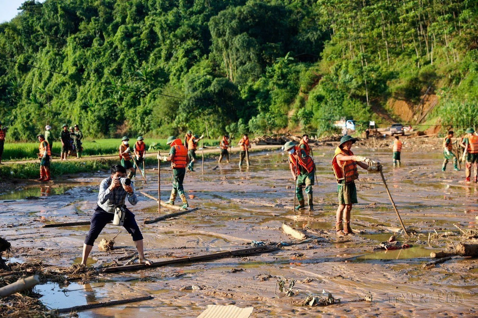 El reportero Duong Giang de la VNA trabaja en la zona del deslizamiento de tierra en la aldea Nu, comuna de Phuc Khanh, distrito de Bao Yen, provincia de Lao Cai (12 de septiembre de 2024). Foto: VNA