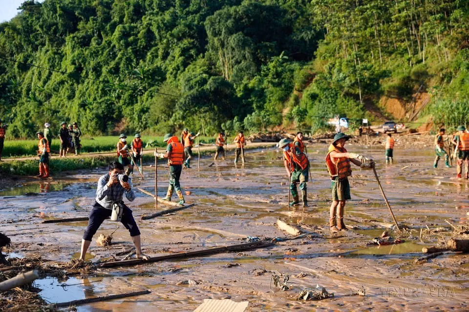 El reportero Duong Giang de la VNA trabaja en la zona del deslizamiento de tierra en la aldea Nu, comuna de Phuc Khanh, distrito de Bao Yen, provincia de Lao Cai (12 de septiembre de 2024). Foto: VNA