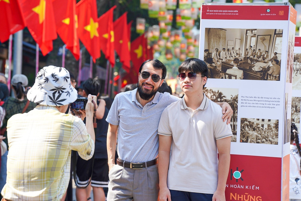 Turistas disfrutan tomando fotografías de recuerdo en la calle de Phung Hung. (Fuente:VNA)