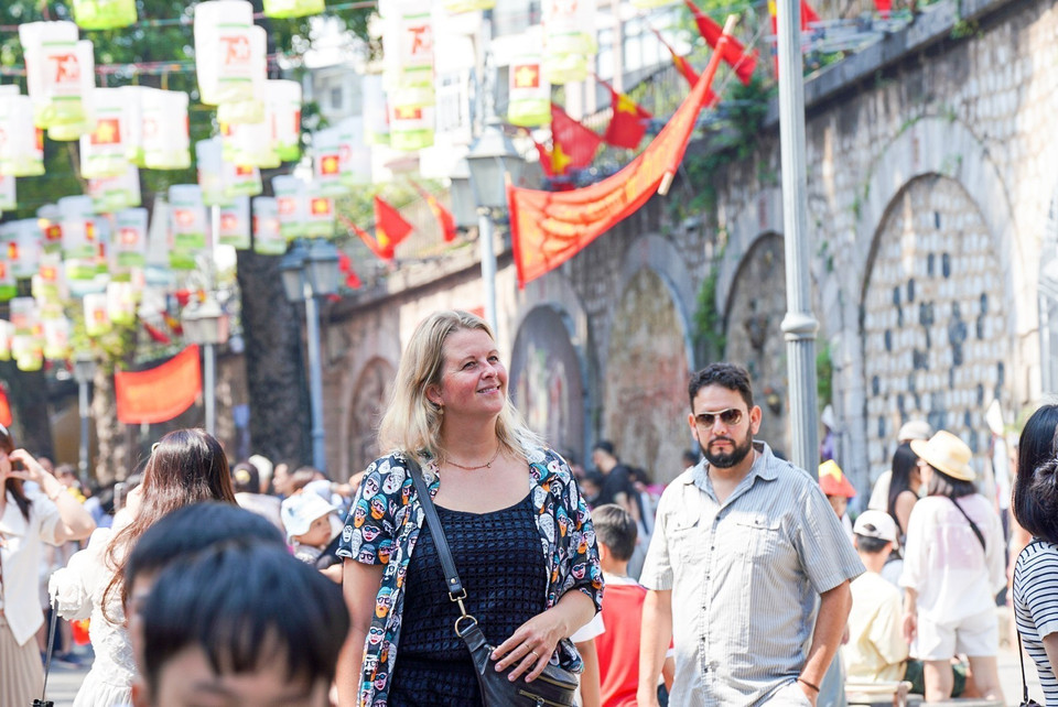 Turistas extranjeros disfrutan de un día memorable en la calle de Phung Hung. (Fuente:VNA)