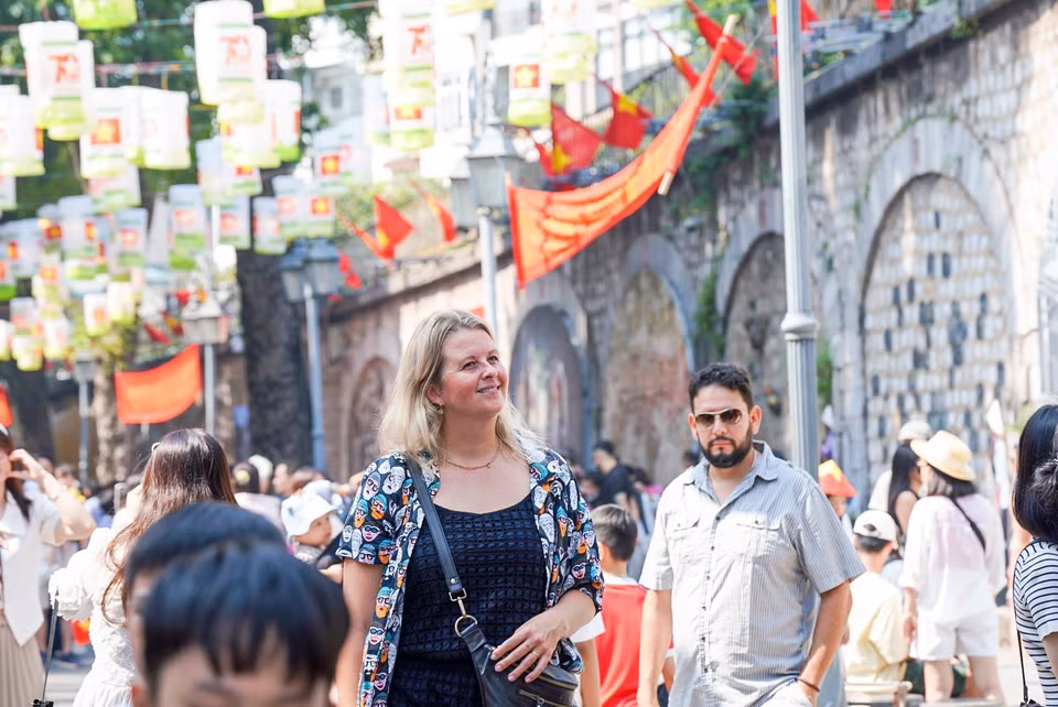 Turistas extranjeros disfrutan de un día memorable en la calle de Phung Hung. (Fuente:VNA)