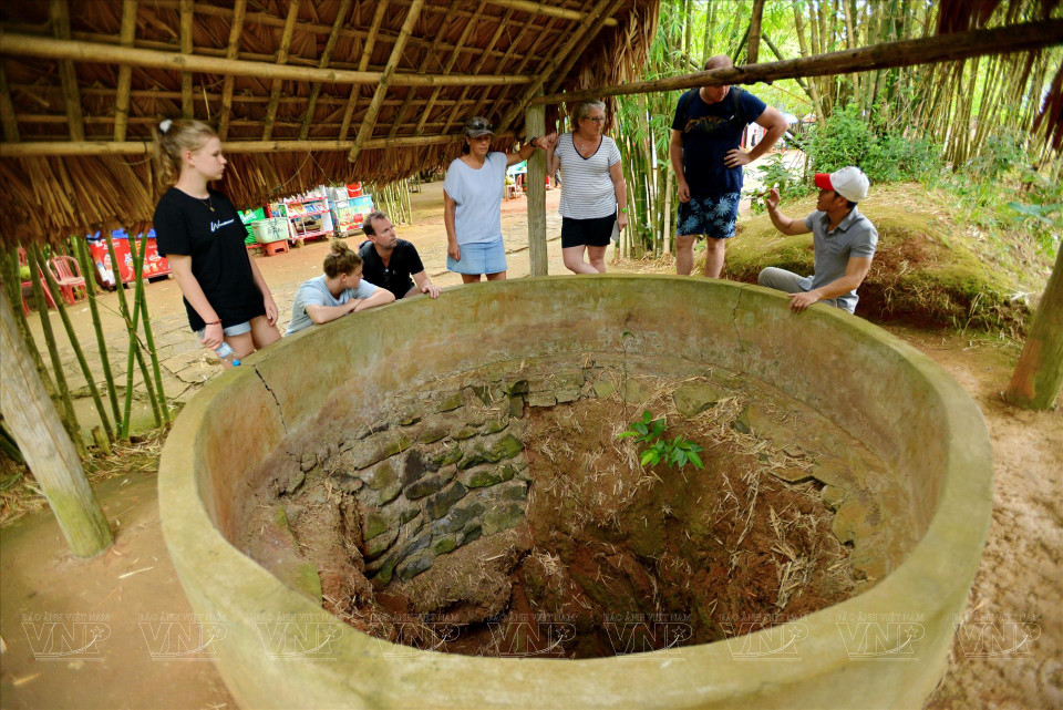 Turistas extranjeros en un pozo utilizado para recoger agua para uso diario en los túneles de Vinh Moc. Foto: Thanh Hoa/Revista Vietnam