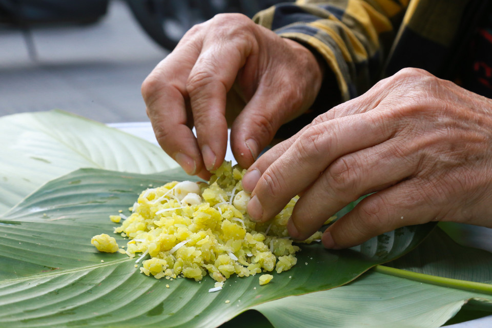 Los granos de arroz verde se machacan en el mortero. Foto: Quynh Anh/VNA