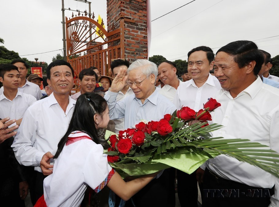 Los niños de la aldea de Thuong Dien, comuna de Vinh Quang, entregan flores para dar la bienvenida al secretario general Nguyen Phu Trong, que asiste a la Fiesta de Gran Unidad Nacional en la ciudad de Hai Phong, 15 de noviembre de 2017. (Fuente: VNA)