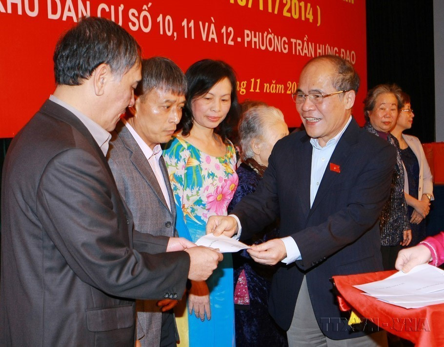 El presidente de la Asamblea Nacional, Nguyen Sinh Hung, entrega obsequios a familias culturales típicas en la Fiesta de Gran Unidad Nacional entre las zonas residenciales números 10, 11 y 12, distrito de Tran Hung Dao, Hanoi, en 2014. (Fuente: VNA)