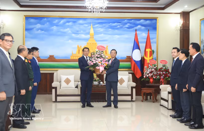 El embajador Nguyen Minh Tam entrega las flores del secretario general del Partido, To Lam, a la Comisión de Relaciones Exteriores del Comité Central del PPRL para felicitar al partido por su 71.º aniversario de fundación. (Foto: VNA)