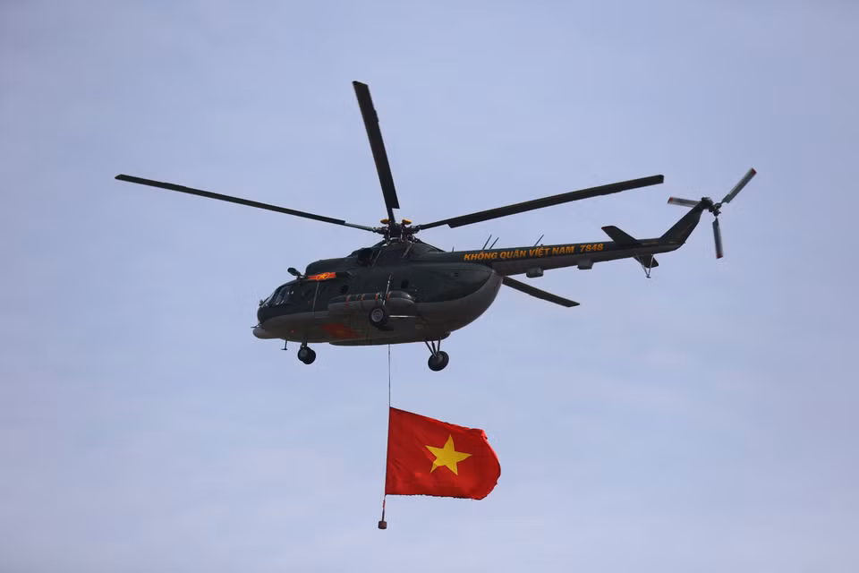 Los helicópteros de la Fuerza Aérea de Vietnam ondean la bandera nacional en el cielo. (Foto: VNA)