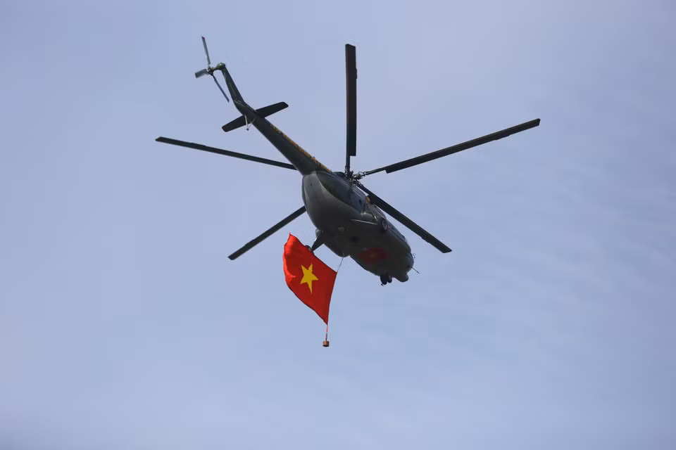 Los helicópteros de la Fuerza Aérea de Vietnam ondean la bandera nacional en el cielo. (Foto: VNA)