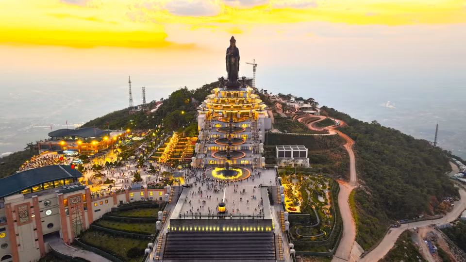 Vista panorámica del Área Turística Nacional de la montaña Ba Den al atardecer, destacando el conjunto de obras religiosas y el complejo arquitectónico iluminado con luces brillantes. (Foto: VNA)
