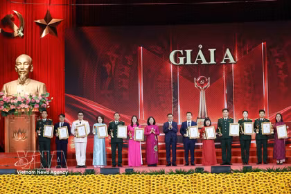 Tran Cam Tu, miembro del Buró Político y permanente del Secretariado del Comité Central del Partido Comunista de Vietnam, y Bui Thi Minh Hoai, presidenta del Comité Central del Frente de la Patria de Vietnam, entregaron el Premio A a los autores y grupos de autores. (Foto: VNA)