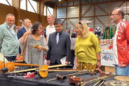 Los delegados aprenden sobre instrumentos musicales tradicionales vietnamitas, que se exhiben en el 4º Festival de Japón de Maintenon-Pierres. Foto: VNA
