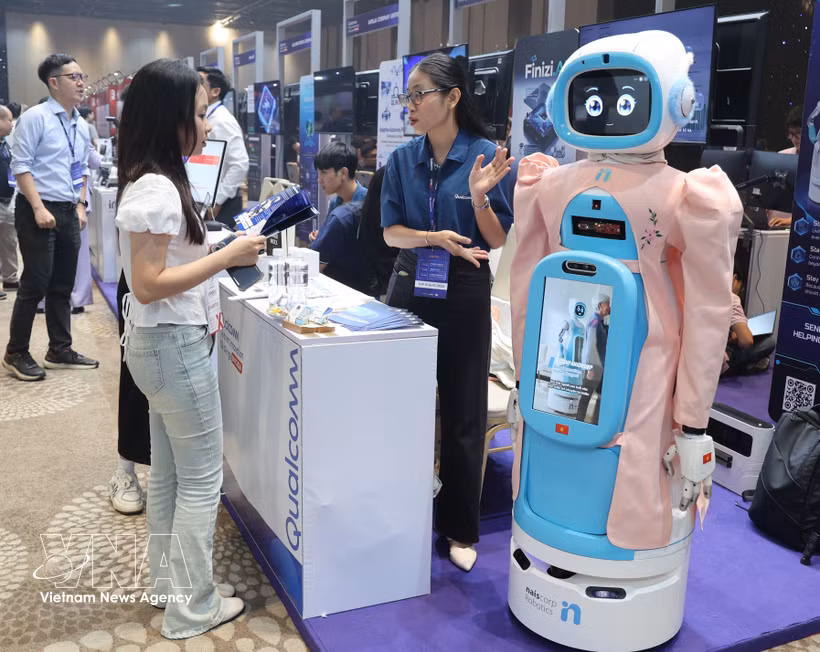 Visitantes estudian un modelo de robot diseñado para el cuidado de personas mayores en el stand de Qualcomm. (Foto: VNA)