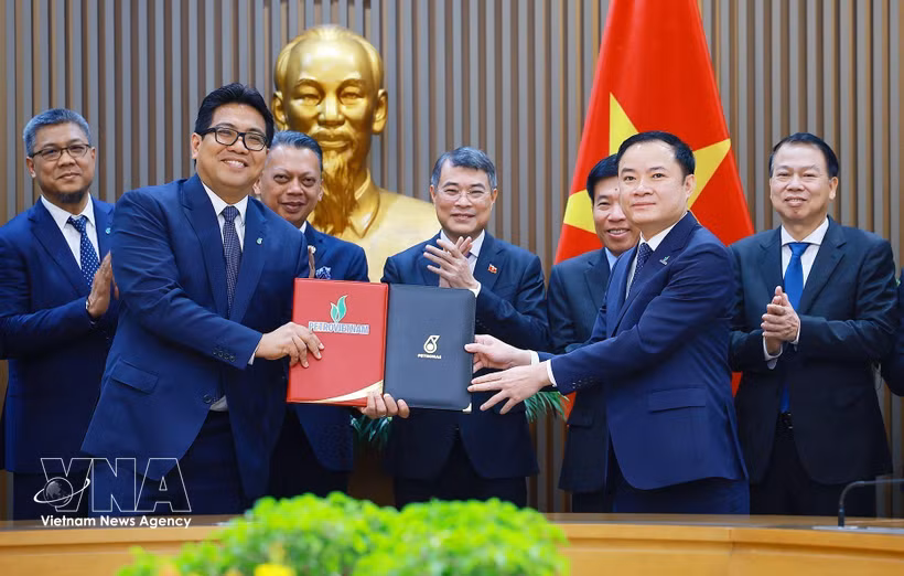 El primer ministro Le Minh Hung presencia la firma de un acuerdo de alianza estratégica entre Petrovietnam y PETRONAS. (Fuente: VNA)