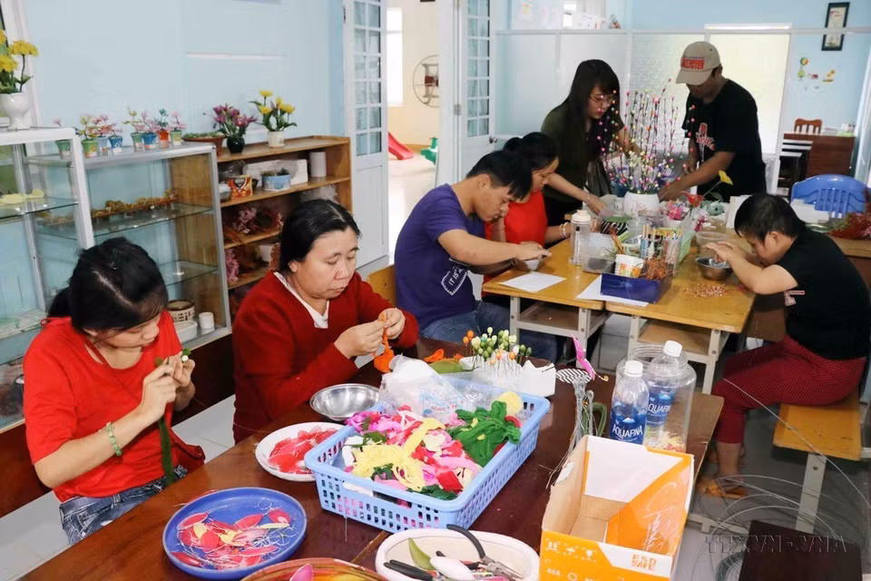 Las víctimas del agente naranja atienden a una clase vocacional para hacer flores de seda en una de las instalaciones de la Asociación de Víctimas del Agente Naranja/Dioxina en la ciudad de Da Nang. (Foto: VNA)