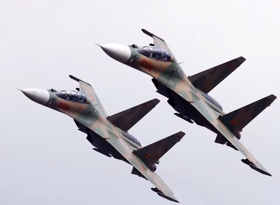 Los Su30-MK2 inclinan sus alas al pasar sobre las gradas para saludar a los delegados presentes en la ceremonia. (Foto: VNA)