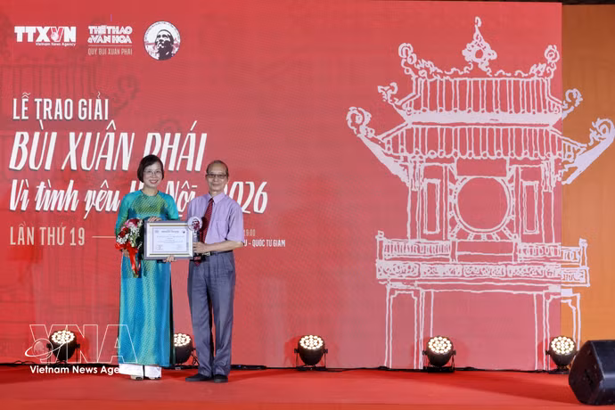 Vu Viet Trang, directora general de la VNA entrega el premio al escritor Bang Viet. Foto: VNA