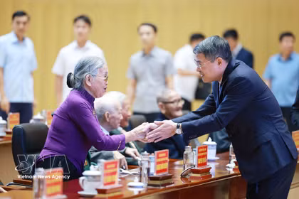 El primer ministro Le Minh Hung saluda a los militantes mayores. (Foto: VNA)