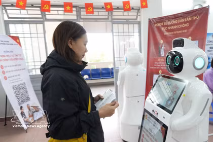 Una ciudadana interactúa con un robot integrado con inteligencia artificial para obtener orientación en el Centro de Servicios Administrativos Públicos del barrio de Xuan Huong-Da Lat, provincia de Lam Dong. (Foto: VNA)
