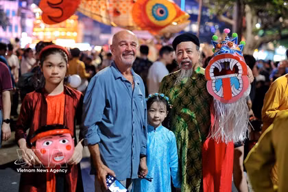 Turistas extranjeros se sumergen en el ambiente festivo de la Fiesta del Medio Otoño en la zona del lago Hoan Kiem, Hanoi. (Foto: VNA)