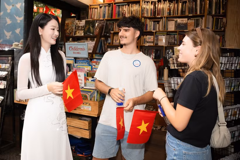 Los turistas internacionales se emocionan al recibir la bandera roja con una estrella amarilla al visitar Ciudad Ho Chi Minh. (Foto: Vietnam+) 