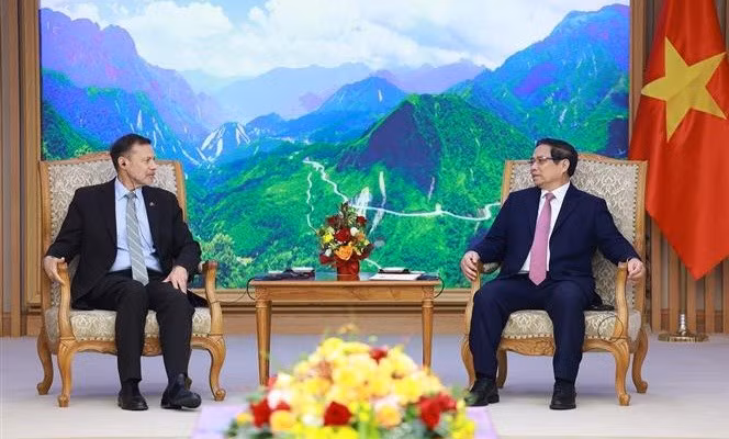 El primer ministro de Vietnam, Pham Minh Chinh (derecha), conversa con el saliente embajador de Australia en Hanoi, Andrew Goledzinowski. (Foto: VNA)