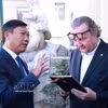 El vicepresidente del Comité Popular de Hanoi, Do Anh Tuan (izquierda), obsequia un regalo al vicealcalde de Praga, Petr Hlavacek. (Foto: VNA)