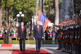 El secretario general del Partido Comunista de Vietnam, To Lam (derecha), y el secretario general del Partido Popular Revolucionario y presidente de Laos, Thongloun Sisoulith, pasan revista a la guardia de honor. (Foto: VNA)