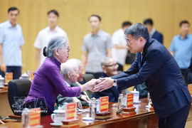 El primer ministro Le Minh Hung saluda a los militantes mayores. (Foto: VNA)