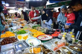 Las personas compran comida en un mercado de la provincia de Narathiwat, en Tailandia. (Foto: AFP/VNA)