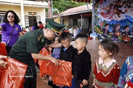 Oficiales de la Guardia Fronteriza de la provincia norvietnamita de Lao Cai entrega obsequios a los estudiantes del centro educativo de Dao Dan San, en la comuna de Si Ma Cai. (Foto: VNA)