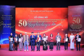 Nguyen Xuan Bac (quinto, desde la izquierda), director del Departamento de Artes Escénicas, y Doan Thi Tuyet Nhung (en el quinto lugar, desde la derecha), directora general adjunta de VNA, entregan flores y certificados a los autores de las obras musicales seleccionadas. (Foto: VNA)