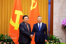 Nguyen Xuan Thang, presidente del Consejo Teórico Central y subjefe del Comité Directivo para el balance de los 100 años de liderazgo del PCV en la Revolución vietnamita y los 40 años de implementación de la Plataforma para la construcción nacional en el período de transición al socialismo, y Li Shulei, miembro del Buró Político, integrante del Secretariado del Comité Central del PCCh y jefe de su Departamento de Publicidad. (Foto: VNA)