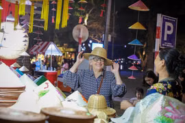 Una extranjera se deleita con los productos tradicionales vietnamitas cuando visita Hanoi (Foto: VNA)