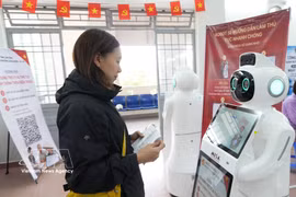 Una ciudadana interactúa con un robot integrado con inteligencia artificial para obtener orientación en el Centro de Servicios Administrativos Públicos del barrio de Xuan Huong-Da Lat, provincia de Lam Dong. (Foto: VNA)