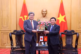 El presidente del Consejo Teórico Central del PCV, Nguyen Xuan Thang (derecha), entrega un obsequio al secretario general interino del PLD, Koichi Hagiuda. (Foto: VNA)