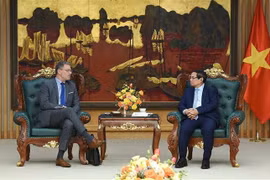 El primer ministro Pham Minh Chinh (derecha) dialoga con el director de Asuntos Gubernamentales e Internacionales de EDF, Erkki Maillard. (Foto: VNA)