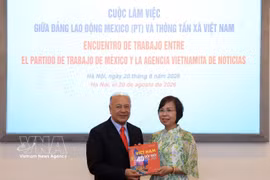 La directora general de la VNA, Vu Viet Trang, obsequia un libro fotográfico al coordinador nacional del PT, Alberto Anaya Gutiérrez. (Foto: VNA)