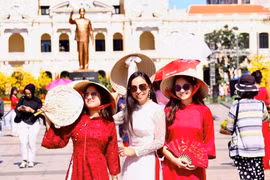 Vietnamitas que regresan del exterior exploran la calle de flores de Nguyen Hue. (Foto: qdnd.vn)