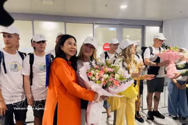 Dang Huong Giang (izquierda), directora del Departamento de Turismo de Hanoi, entrega flores a la visitante extranjera número cinco millones de Hanoi en 2026 y a su grupo turístico procedente de España en el Aeropuerto Internacional Noi Bai. (Foto: VNA)