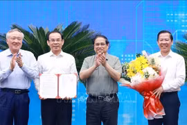 El primer ministro vietnamita, Pham Minh Chinh (segundo desde la derecha), entrega a las autoridades locales la decisión que aprueba la planificación de Ciudad Ho Chi Minh. (Foto: VNA)