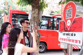 Los visitantes escanean un código QR en el marcador del kilómetro 0 de la provincia de Ha Giang para acceder a información turística. (Foto: VNA)