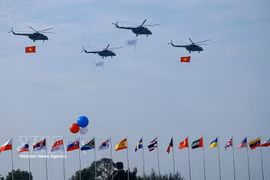 Helicópteros realizan un vuelo de exhibición durante la ceremonia de inauguración de la Exposición Internacional de Defensa de Vietnam 2024. (Foto: VNA)