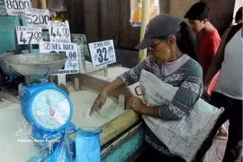 Las personas compran arroz en un mercado en Filipinas. (Foto: AFP/VNA)