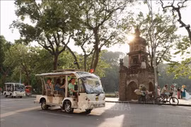 Turistas recorren el lago Hoan Kiem en coches eléctricos. (Foto: VNA)