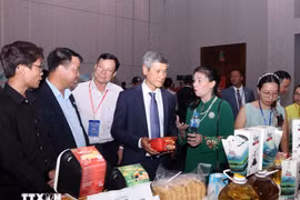 El embajador de Hanoi en Phnom Penh, Nguyen Minh Vu, y empresarios camboyanos visitan el stand vietnamita. (Foto: VNA)
