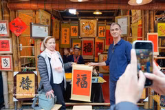 Los turistas internacionales disfrutan de la tradición de recibir caligrafía auspiciosa a principios de año. (Foto: VNA)